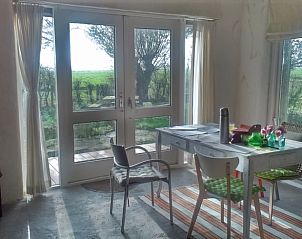 Lichte eetkamer in vakantiehuisje in Wyns met uitzicht op het Friese platteland, Friesland.