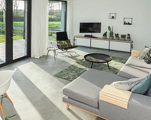 Lichte woonkamer met grote ramen in Huisje in Bergharen, vakantiewoning in Rivierengebied, Gelderland.