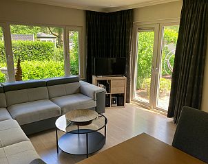 Lichte woonkamer met uitzicht op tuin bij Chalet in Arnhem, vakantiehuis in Rivierengebied, Gelderland.