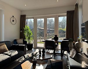 Lichte woonruimte in Chalet in Arnhem met uitzicht op de groene omgeving van Gelderland.