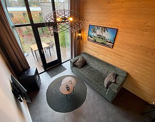 Uitzicht vanuit de woonkamer van Chalet in Arnhem op het terras en de groene omgeving, ideaal voor een vakantie in het Rivierengebied.