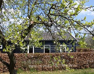 Lentezicht op Vakantiehuis in Culemborg, omgeven door bloeiende bomen in het groene Rivierengebied.