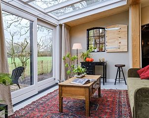 Gezellige woonkamer in Vakantiehuis in Culemborg met uitzicht op de tuin.