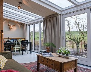 Eethoek in Vakantiehuis in Culemborg met glazen dak en tuinzicht.