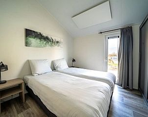 Gezellige woonkamer in Vakantiehuis Hackfort 6 met uitzicht op de tuin in Gelderland.