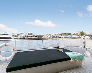 Terras met uitzicht op de jachthaven in The Queen vakantiehuis, gelegen in het schilderachtige Kerkdriel.