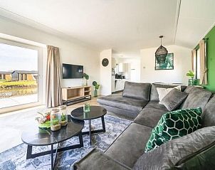 Ruime woonkamer van Vakantiehuis Velthorst 6 in Kerkdriel met uitzicht op de tuin en moderne inrichting.