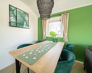 Stijlvolle eetkamer in Vakantiehuis Velthorst 4, Kerkdriel, met uitzicht op de groene omgeving.