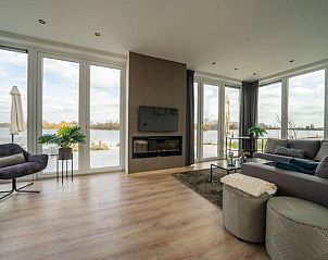 Ruime woonkamer met uitzicht op het water in Vakantiehuis Pavilion l'etage 10, Kerkdriel, Gelderland.