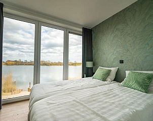 Slaapkamer met uitzicht op het meer in Vakantiehuis Pavilion l'etage 10, Kerkdriel, Gelderland.