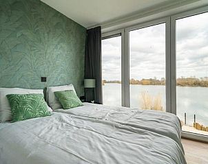 Slaapkamer met groene accenten en uitzicht in Vakantiehuis Pavilion l'etage 10, Kerkdriel.