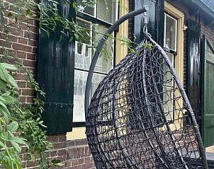 Gezellige zithoek buiten bij Vakantiehuisje in Tricht, ideaal voor ontspanning in de natuur.