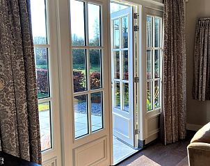 Lichte binnenruimte met openslaande deuren in Vakantiehuis in Buurmalsen, gelegen in het groene Rivierengebied, Gelderland.