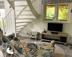 Gezellige woonkamer in Vakantiehuisje in Hurwenen, Rivierengebied, Gelderland met kleurrijke stoelen.