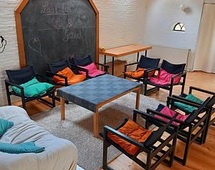 Comfortabele zithoek met kleurrijke kussens in Vakantiehuisje in Hurwenen