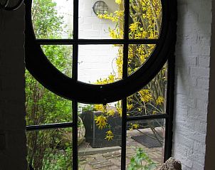 Uitzicht vanuit het ronde raam van Vakantiehuisje in Hurwenen, Gelderland