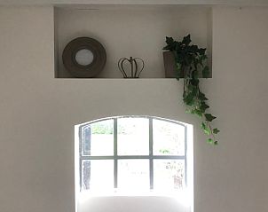 Vakantiehuisje in Buren, sfeervolle binnenruimte met raamdecoratie in Gelderland.