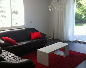 Gezellige woonkamer in vakantiehuis de Wielewei, Eck en Wiel, Gelderland met comfortabele zithoek en uitzicht op groene tuin.