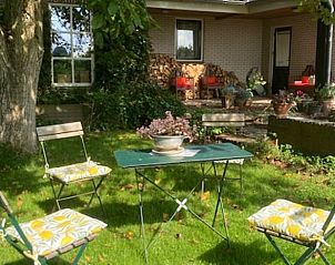 Gezellig terras bij Vakantiehuisje in Ommeren, Rivierengebied, Gelderland, met zitje onder de bomen.