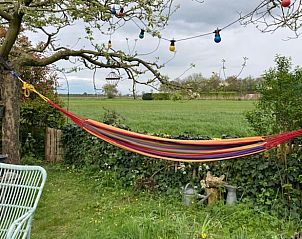 Bloemrijke tuin met boekenhoek bij Huisje in Zoelen, vakantiehuis in Rivierengebied, Gelderland.
