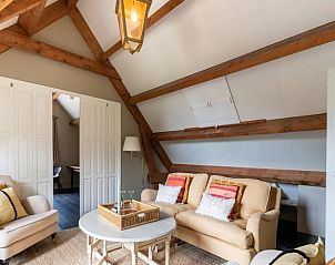 Lichte woonkamer in Vakantiehuis in Deil, Gelderland met gezellige zithoek en decoratieve details.