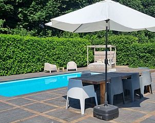Zwembad met terras en parasol bij Vakantiehuisje in Winssen, Gelderland.