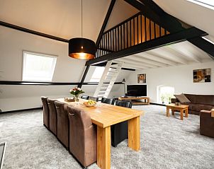 Ruime woonkamer met houten eettafel in Vakantiehuisje in Winssen, Gelderland.