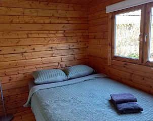Knusse slaapkamer met houten wanden in Vakantiehuisje in Winssen, Rivierengebied, Gelderland.