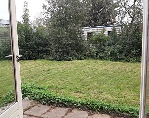 Uitzicht op tuin vanuit Vakantiehuisje in Winssen, omringd door de natuur van Gelderland.