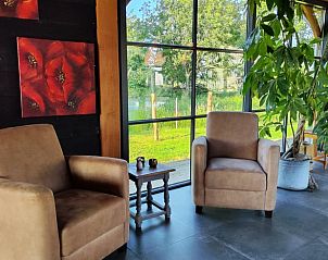 Comfortabele zithoek in Vakantiehuisje in Herveld, Gelderland. Ontspan met uitzicht op de groene omgeving.