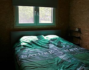 Slaapkamer met uitzicht in Vakantiehuis in Herveld, rustgevende vakantiewoning in Rivierengebied, Gelderland.