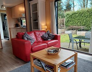 Comfortabele zithoek in Vakantiehuisje in Wolfheze met uitzicht op de tuin.