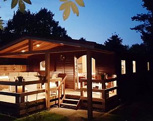 Sfeervol verlicht vakantiehuis in Wolfheze bij nacht, gelegen in het Rivierengebied, Gelderland.