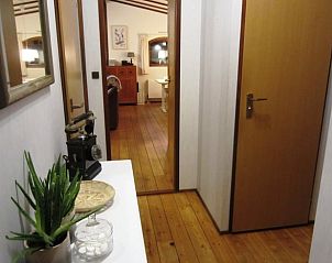 Gezellige gang in vakantiehuis in Wolfheze leidt naar de woonkamer, gelegen in Gelderland.