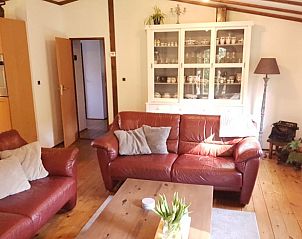 Woonkamer van vakantiehuis in Wolfheze met leren banken, gelegen in het Rivierengebied, Gelderland.