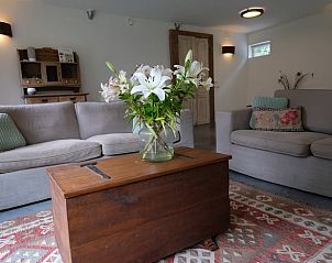 Gezellige zithoek in Huisje in Dreumel, vakantiehuis in Rivierengebied Gelderland, met bloemen op de tafel.