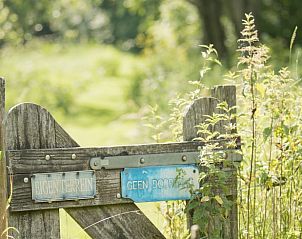 Houten poort met bordjes bij Vakantiehuis in Dreumel, rustieke charme, Gelderland.