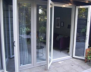 Open deuren naar terras in Vakantiehuis in Dreumel, naadloze binnen-buiten verbinding, Gelderland.