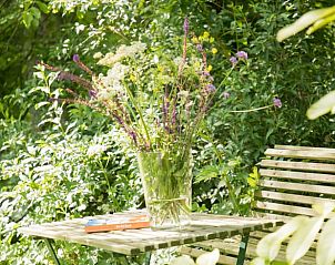 Bloemenvaas op tafel in de tuin bij Vakantiehuis in Dreumel, serene sfeer, Rivierengebied, Gelderland.