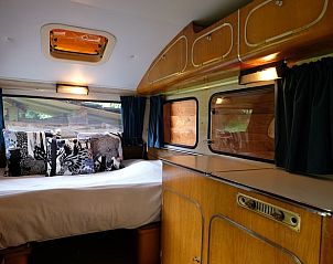 Sfeervolle binnenruimte van het Vakantiehuisje in Dreumel, Gelderland, met comfortabele slaapkamer in een retro caravan.