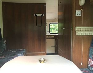 Binnenkant van Vakantiehuis in Dreumel, Gelderland, met een uitnodigende eethoek en houten afwerking.