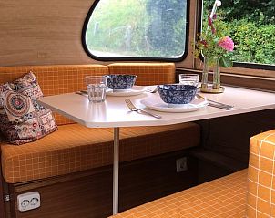 Gezellige eetruimte in Huisje in Dreumel, vakantiehuis in het Rivierengebied van Gelderland, met uitzicht op de groene omgeving.