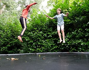 Kinderen spelen op trampoline bij Huisje in Dreumel, plezier voor het hele gezin in Rivierengebied, Gelderland.