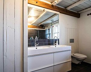 Gezellige woonkamer met houten balken in vakantiehuis DG1294, Gelderland.