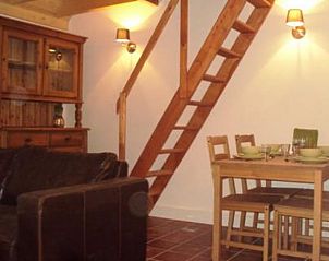 Knusse woonkamer met houten trap in Vakantiehuisje in Toldijk, sfeervol verblijf in Rivierengebied, Gelderland.