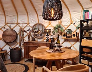 Eethoek in Vakantiehuisje in Toldijk, Gelderland met sfeervolle verlichting en wijn.