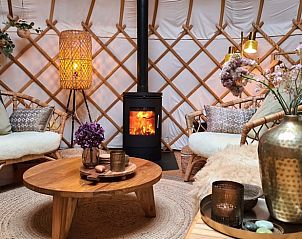 Sfeervolle woonkamer in Huisje in Toldijk, vakantiehuis in Toldijk, met knusse meubels en een brandende haard.