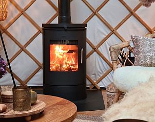 Warme haard in de woonkamer van Huisje in Toldijk, vakantieverblijf in Gelderland, voor ultieme ontspanning.