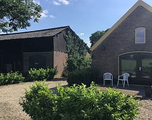 Buitenruimte met zitplaatsen bij Vakantiehuis in Toldijk, omgeven door groen in Gelderland.