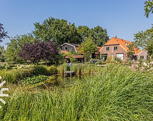 Gezellige eetkamer in vakantiehuis DG1743 in Toldijk, Gelderland met houten balken en veel daglicht.